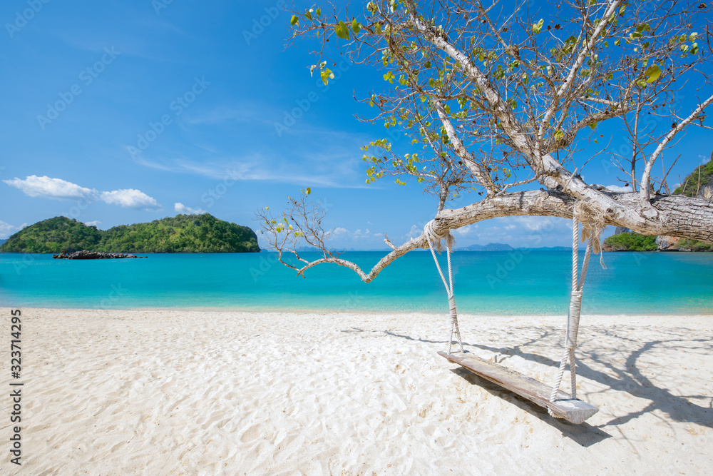Wooden swing hang under tree at Koh Phak Bia Island, Krabi, Thailand. Travel destination and nature environment concept , summer holiday background. Wooden swing hang under tree at Koh Phak Bia Island, Krabi, Thailand. Travel destination and nature environment concept , summer holiday background.