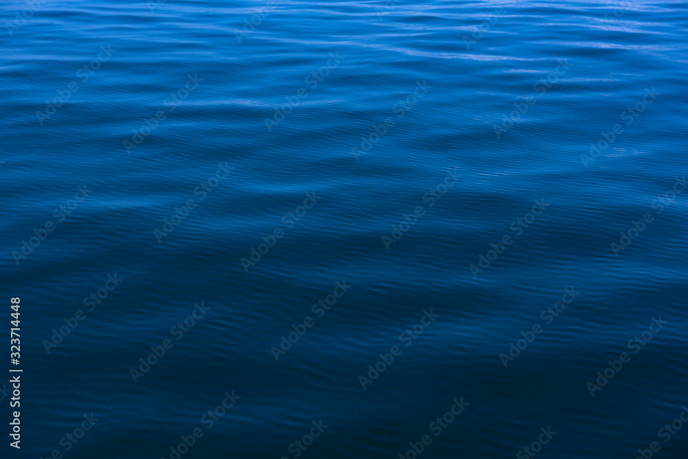 Blue water background with ripples Sea low angle view, Ocean, Wave. Travel destination and nature environment concept - Ocean water surface texture, summer holiday background Blue water background with ripples Sea low angle view, Ocean, Wave. Travel destination and nature environment concept - Ocean water surface texture, summer holiday background
