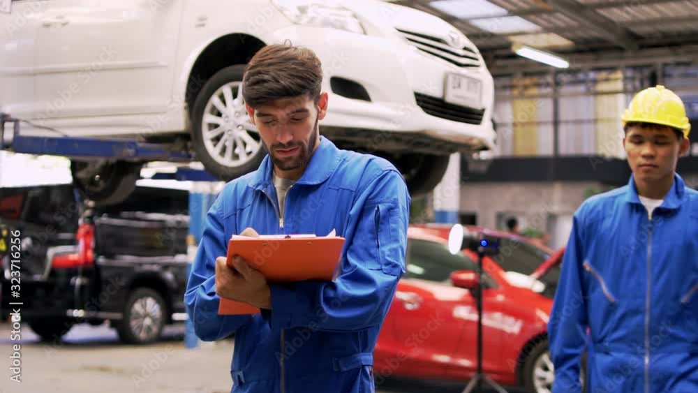 an auto mechanic in a car service, checks the machine diagnostics. Concept: repair of machines, technical maintenance.