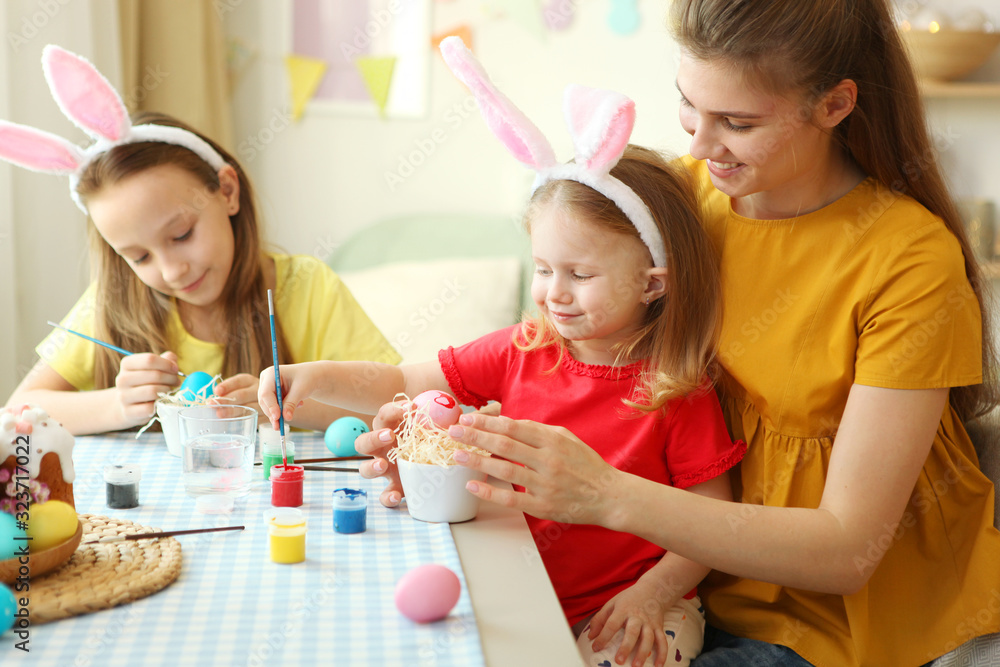 Mom and daughters are painting Easter eggs for the holiday. Easter, traditions. Mom and daughters are painting Easter eggs for the holiday. Easter, traditions.