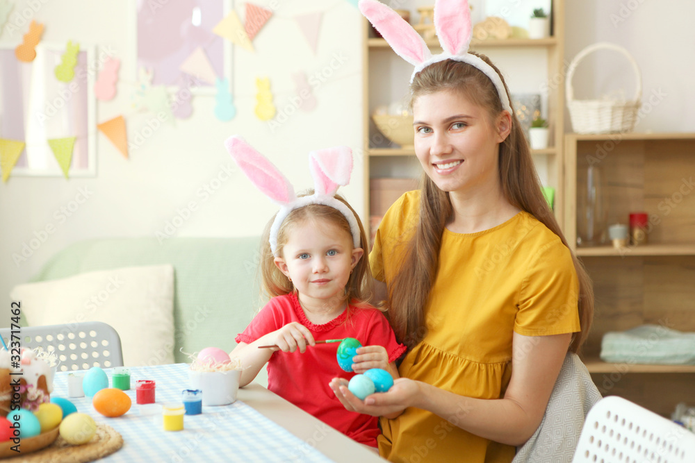 Fototapeta premium Mom and daughter paint Easter eggs for the holiday. Easter traditions.