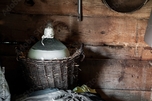 Fotografía Moonshine preparing. Big glass carboy with mash in the basket.