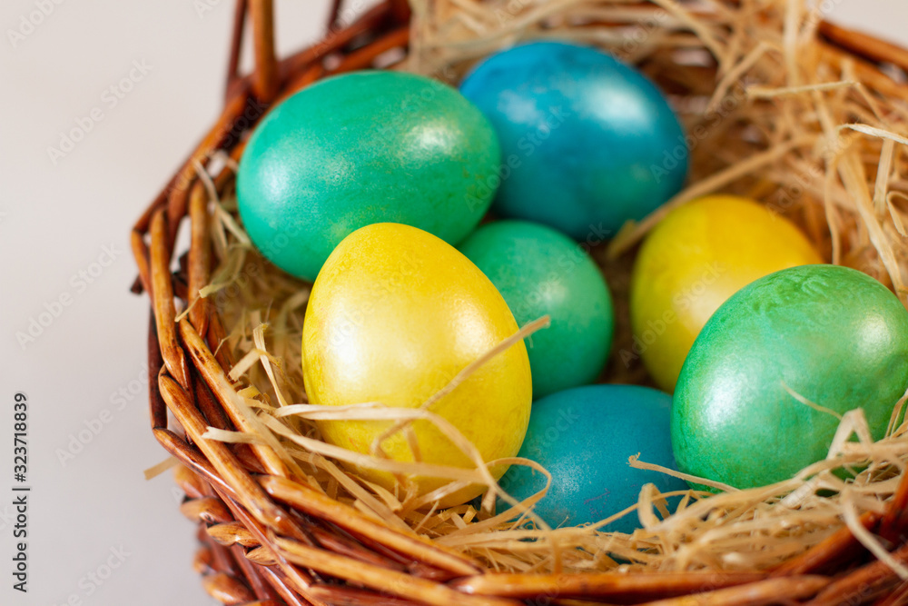 multi-colored easter eggs in a brown basket multi-colored easter eggs in a brown basket