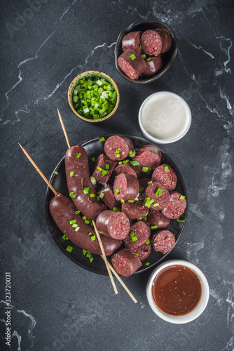 Korean traditional national food. Street home Asian cuisine. Sliced blood sausage soondae or sundae, with rice, noodles, pork meat. With sauces and herbs photo