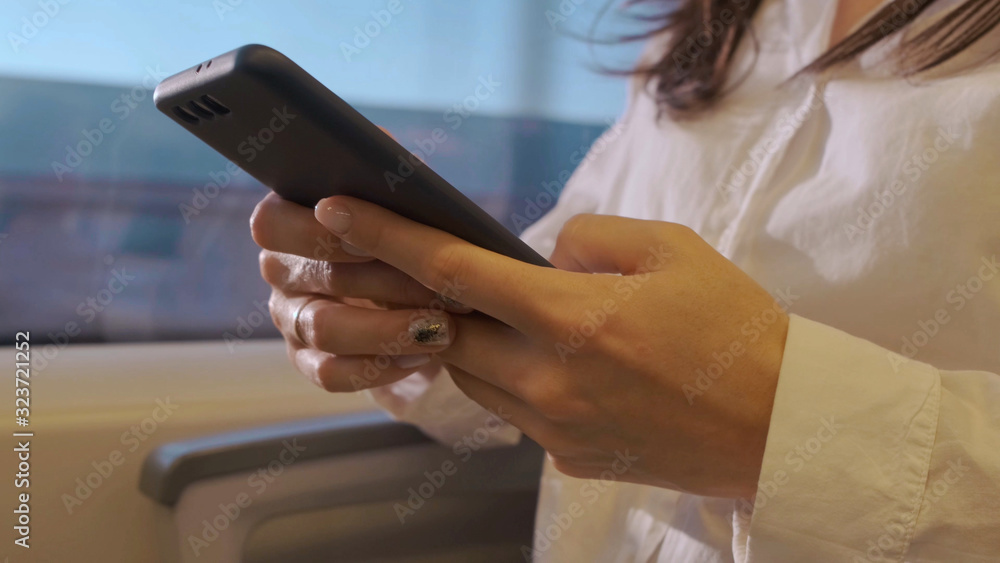Female hands close-up with a phone in public transport.