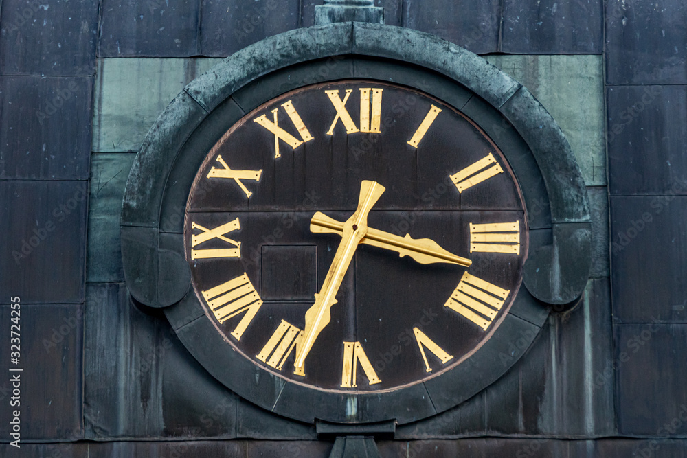 Fototapeta premium Old church clock with golden roman numbers and dials