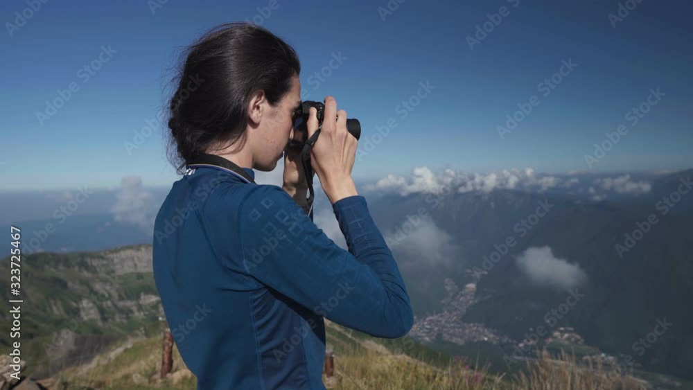 A young woman hiker take a picture of landscape in the mountains. Caucasian nature reserve Sochi A young woman hiker take a picture of landscape in the mountains. Caucasian nature reserve Sochi