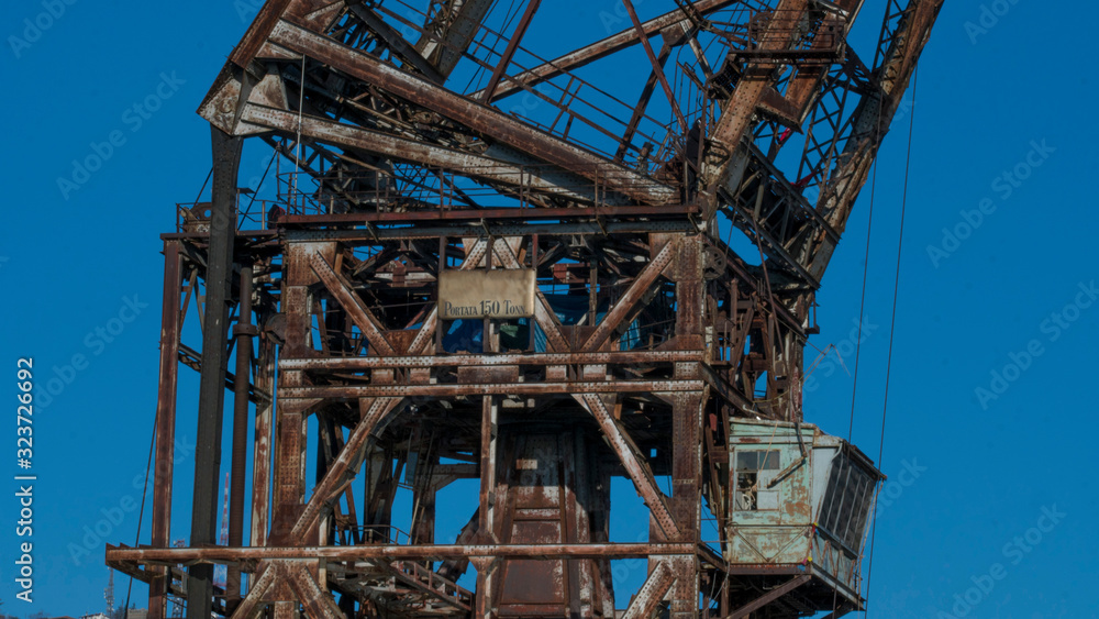 A central part of a big old rusty tower crane on the blue sky background