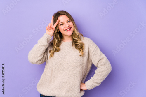 Young caucasian woman isolated on purple background showing number two with fingers.