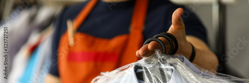 Clothes dry cleaning service worker returning shirts to customer photo