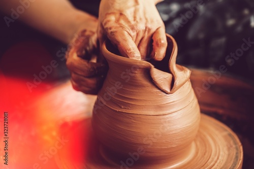 Hands of a potter making clay pot photo