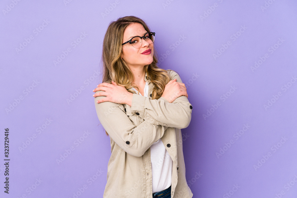 Young caucasian woman isolated on purple background hugs, smiling carefree and happy. Young caucasian woman isolated on purple background hugs, smiling carefree and happy.
