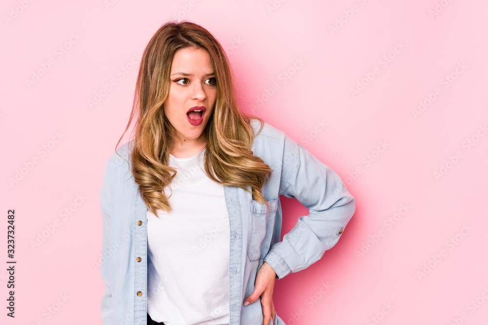 Young caucasian woman isolated on pink background being shocked because of something she has seen. Young caucasian woman isolated on pink background being shocked because of something she has seen.