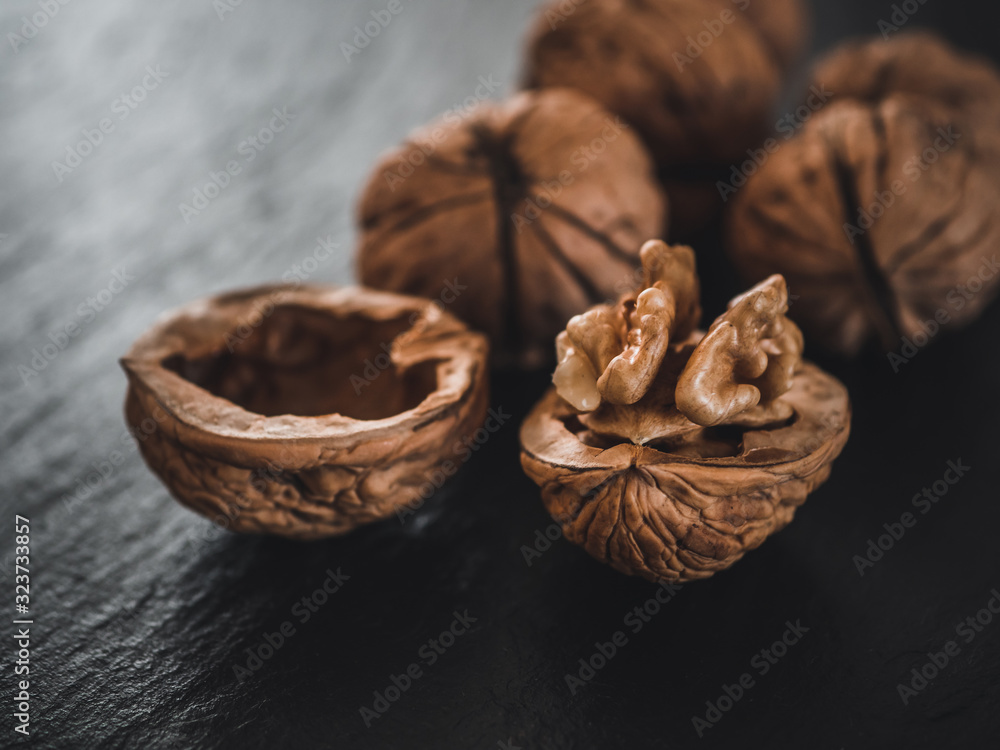 Whole walnuts on dark board. Walnut kernels on dark background. Healthy food nuts. Whole walnuts on dark board. Walnut kernels on dark background. Healthy food nuts.