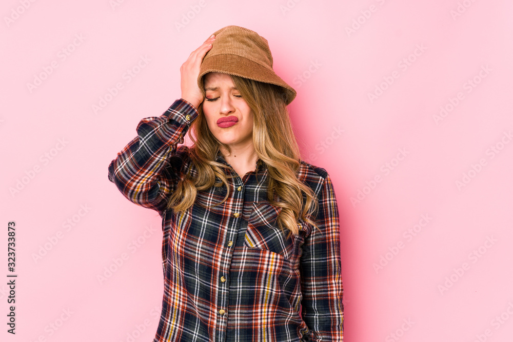 Young caucasian woman wearing a hat isolated tired and very sleepy keeping hand on head. Young caucasian woman wearing a hat isolated tired and very sleepy keeping hand on head.