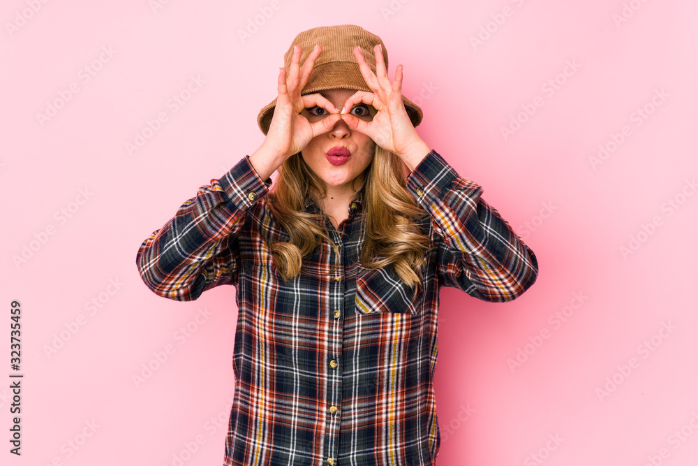 Young caucasian woman wearing a hat isolated showing okay sign over eyes Young caucasian woman wearing a hat isolated showing okay sign over eyes