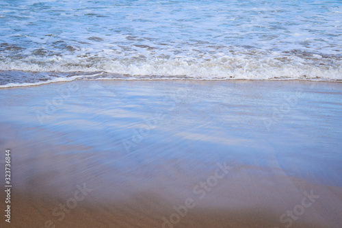 Light reflecting on breaking waves creating pastel prisms