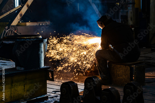 Welding with a graphite electrode, a lot of sparks fly in different directions. Fireworks from the fire from the gas burns of metal.