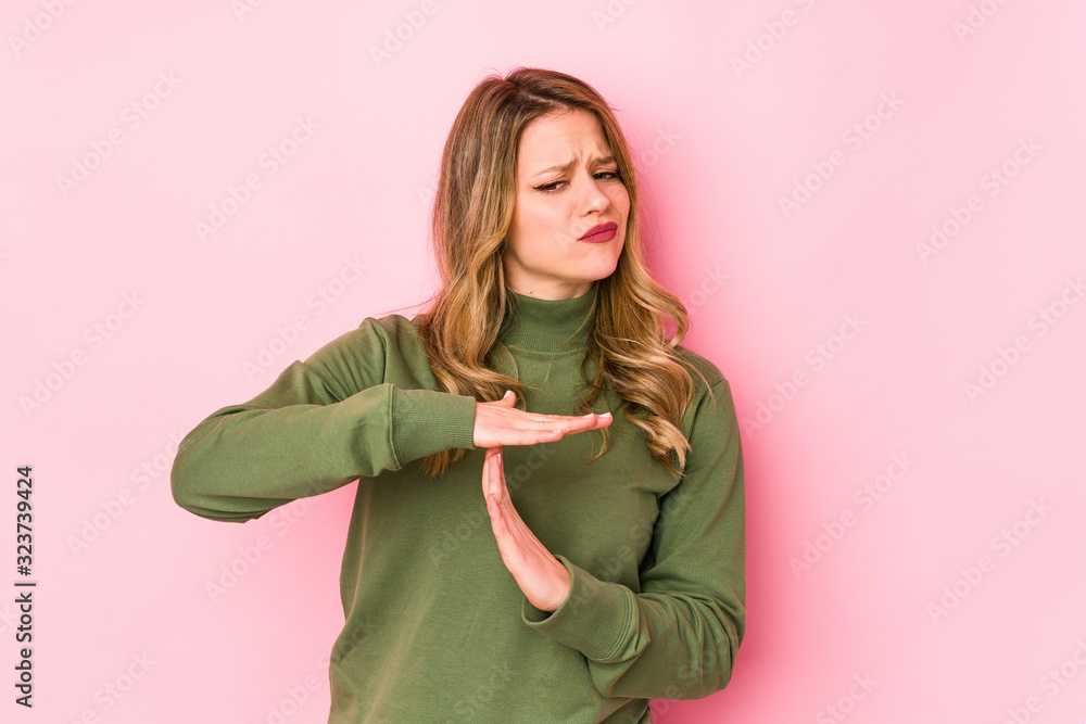 Young caucasian woman isolated on pink background showing a timeout gesture. Young caucasian woman isolated on pink background showing a timeout gesture.