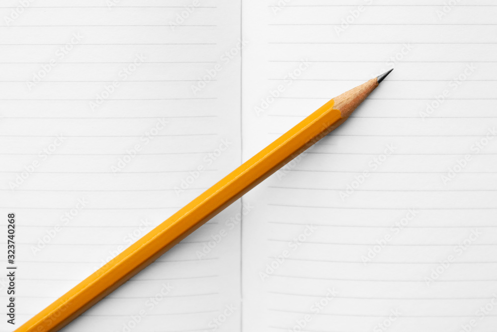 blank white notebook for writing and an orange diagonal pencil, concept for back to school or note paper blank white notebook for writing and an orange diagonal pencil, concept for back to school or note paper