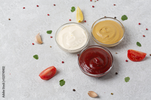Set of sauces: ketchup, mayonnaise and mustard. Different delicious sauces on grey table. Selective focus