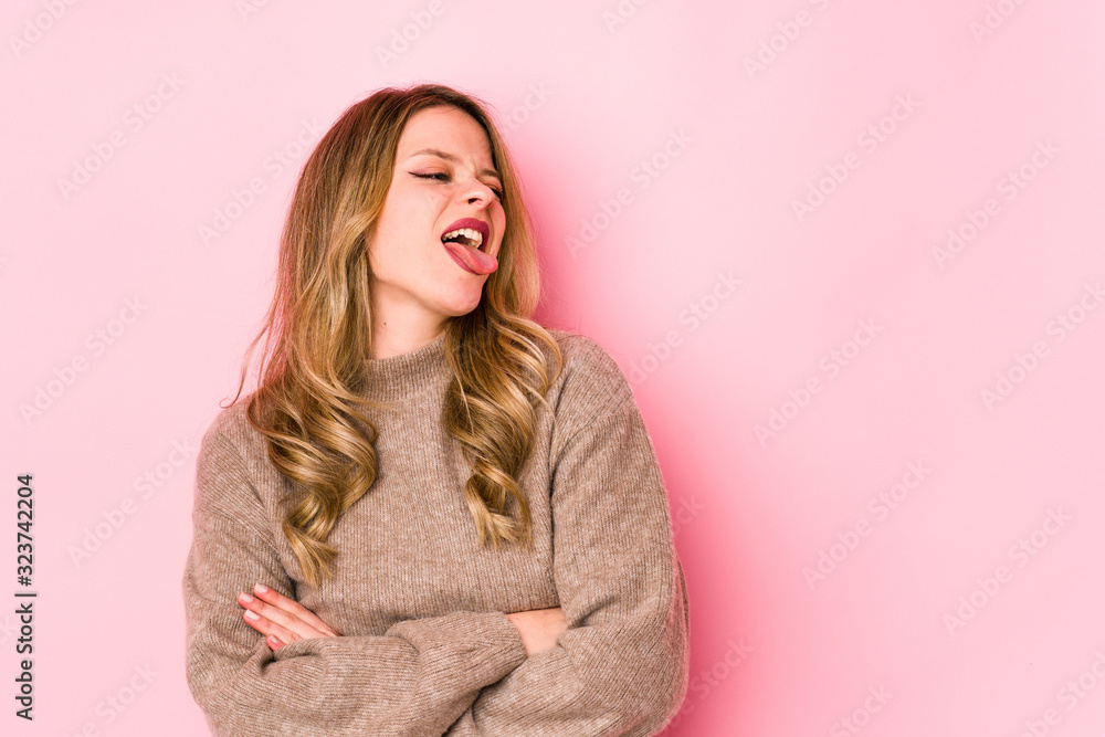 Young caucasian woman isolated on pink background funny and friendly sticking out tongue. Young caucasian woman isolated on pink background funny and friendly sticking out tongue.