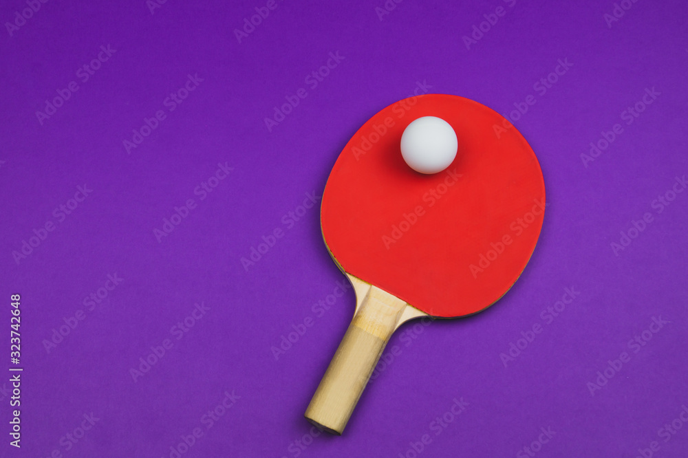 Red table tennis racket with a ball isolated on a colored background. sport equipment for ping pong Red table tennis racket with a ball isolated on a colored background. sport equipment for ping pong