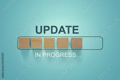 Wooden blocks with the word UPDATE  in loading bar progress.