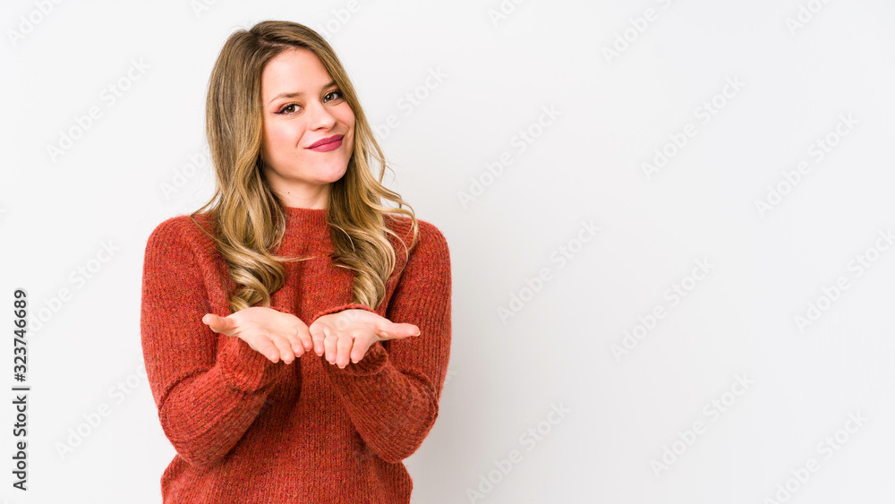 Young caucasian woman isolated on white background holding something with palms, offering to camera. Young caucasian woman isolated on white background holding something with palms, offering to camera.