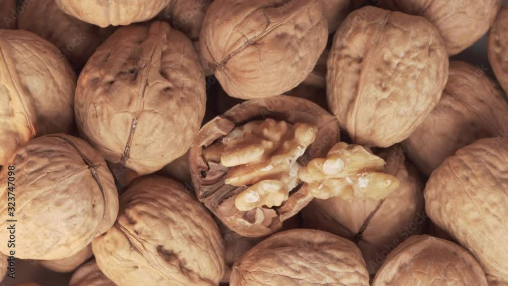 Walnuts group and cracked walnut turning. Top view. Close up. Juglans regia Walnuts group and cracked walnut turning. Top view. Close up. Juglans regia