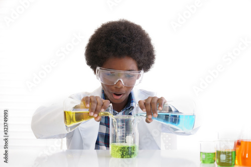 African American boy testing chemistry lab experiment and holding flask with orange liquid