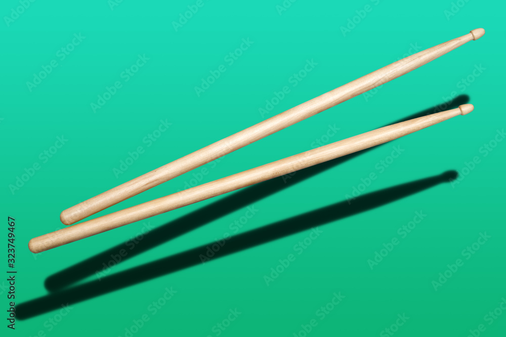 two wooden drumsticks on green background two wooden drumsticks on green background