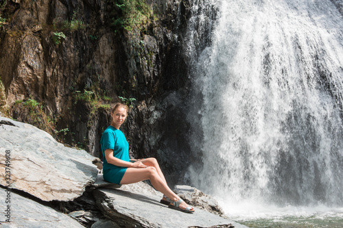 Woman at Korbu Waterfall on the Lake Teletskoye in autumn Altai Mountains. photo