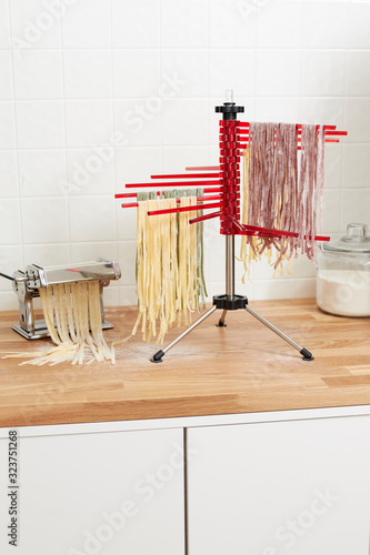 Canvas-taulu fresh pasta drying on rack in kitchen