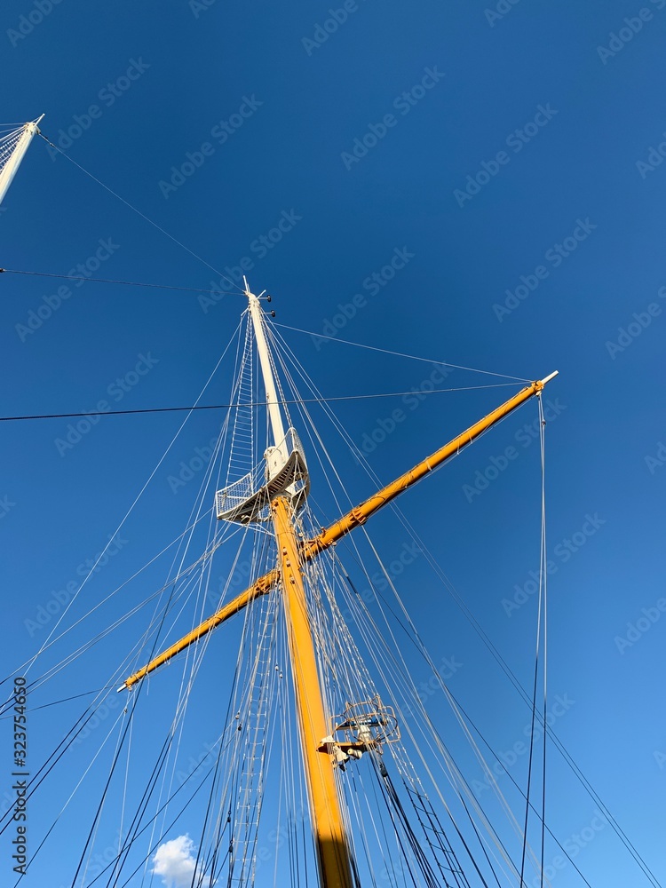 Wooden ship masts in the blue sky background Wooden ship masts in the blue sky background