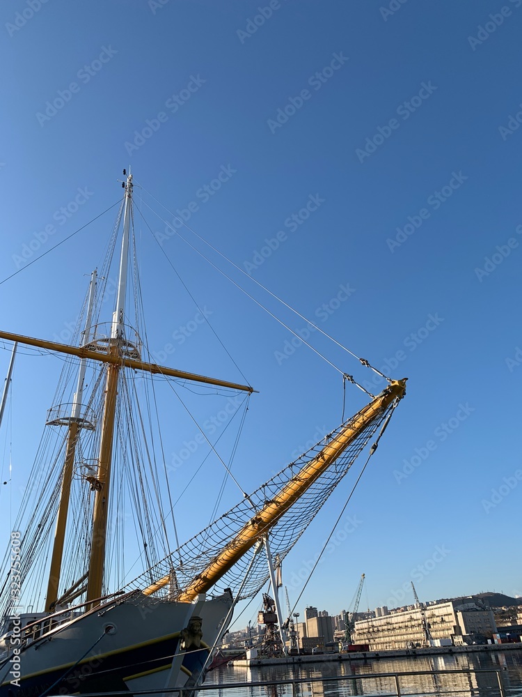 Wooden ship masts in the blue sky background