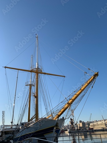 Wooden ship masts in the blue sky background