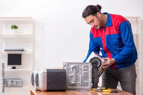Wallpaper Mural Young engineer repairing musical hi-fi system Torontodigital.ca