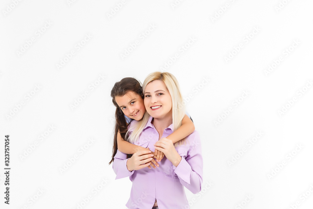 Cheerful mother giving piggyback ride to her daughter against a white background Cheerful mother giving piggyback ride to her daughter against a white background