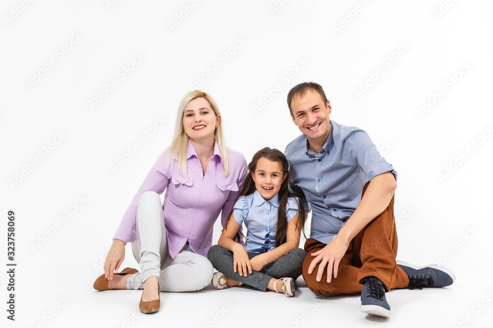 Happy young family with pretty child posing on white background