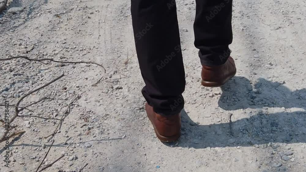 Tracking of male legs walking on the ground. slow motion shot with low-section. Tracking of male legs walking on the ground. slow motion shot with low-section.