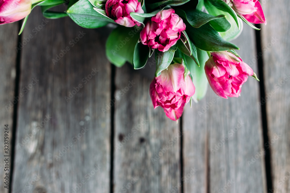 Spring Bouquet of pink peony tulips on a wooden background with space for text.
