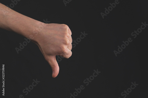 Thumbs down hand isolated on black background photo