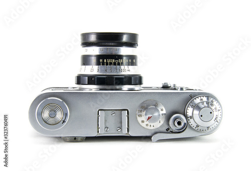 Old film retro camera "fed" with the lens. Metallic black. White isolated background. View from above