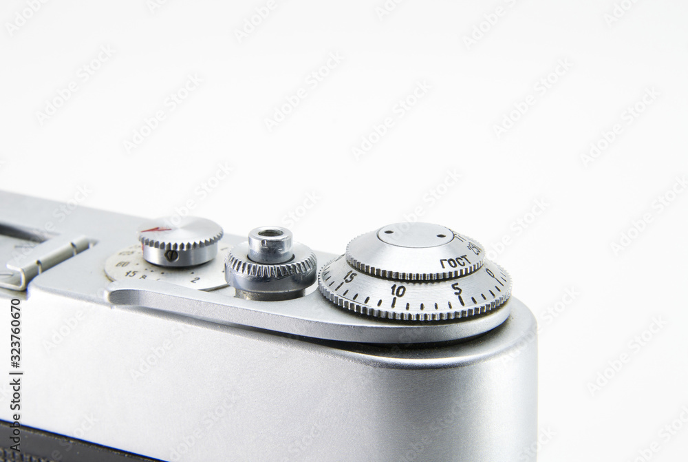 Old film retro camera. Shutter and trigger (button) close-up. Metallic black. White isolated background. Old film retro camera. Shutter and trigger (button) close-up. Metallic black. White isolated background.