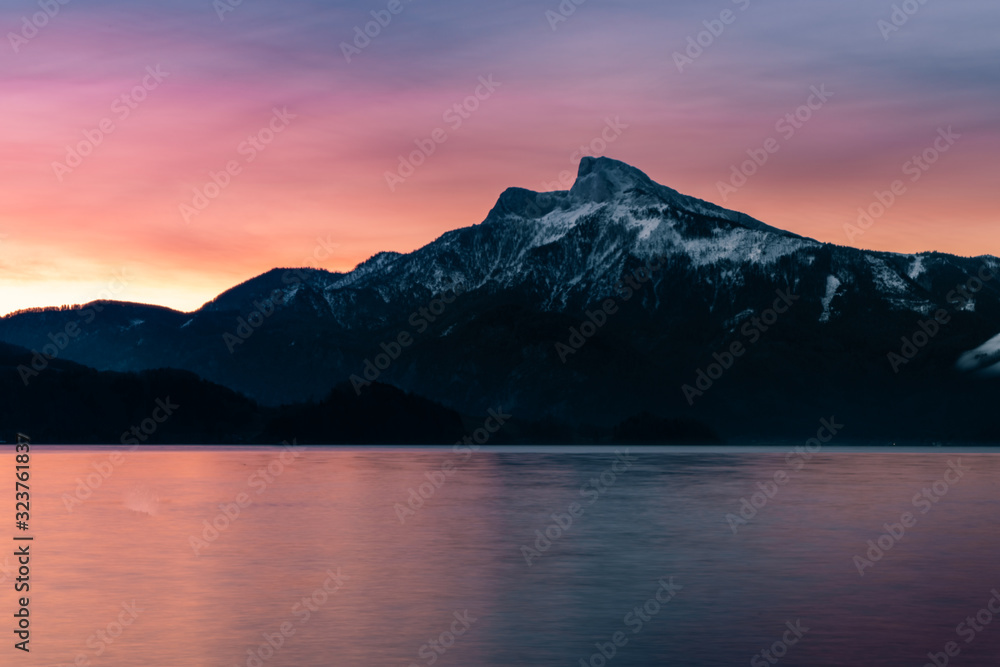 sunrise at the lake on a pier with panorama view to the mountains