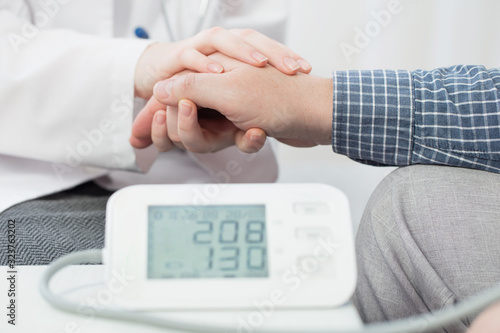 doctor measures the patient’s pressure and holds his hand, healthcare, hospital and medicine concept