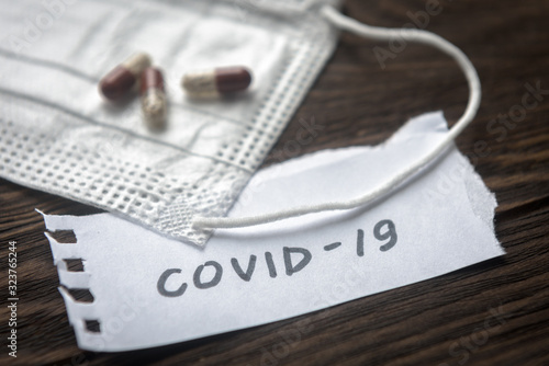 COVID-19, medical mask and pill capsules for treatment coronavirus. Novel corona virus pandemic and medicine concept. photo