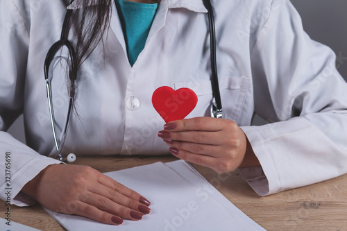 doctor with the stethoscope holding red heart