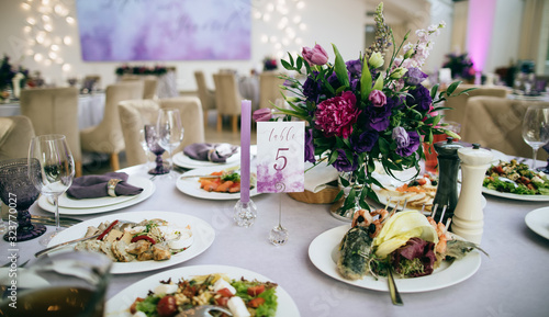  Ideas for wedding. Festive table setting with food on plate and purple flowers